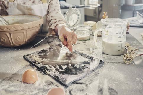 Dispositivo de MediaMarkt sobre la encimera de la cocina cubierto de ingredientes para hornear.